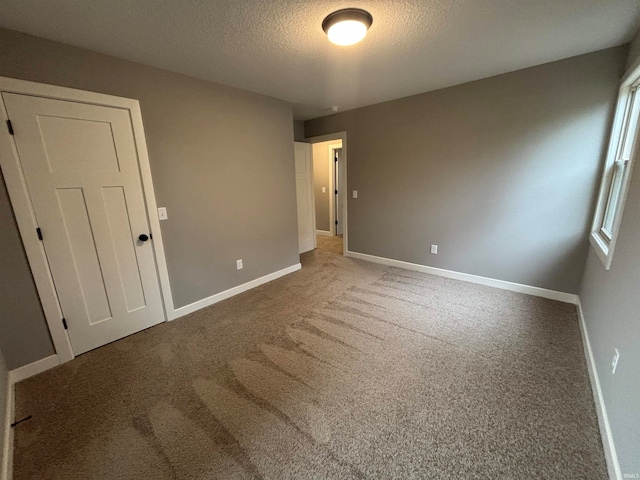 unfurnished bedroom with a textured ceiling and carpet floors