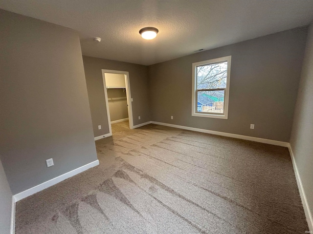 empty room featuring carpet and a textured ceiling