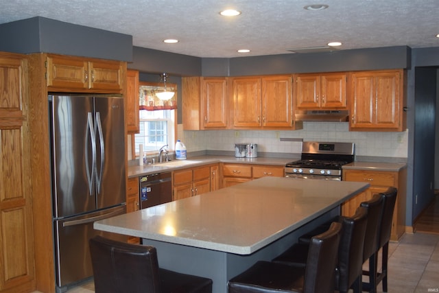 kitchen with a center island, sink, stainless steel appliances, a kitchen bar, and light tile patterned floors