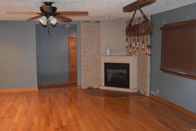 unfurnished living room featuring ceiling fan, wood-type flooring, and a textured ceiling