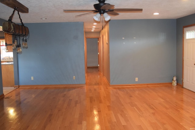 interior space featuring ceiling fan, sink, a textured ceiling, and light wood-type flooring