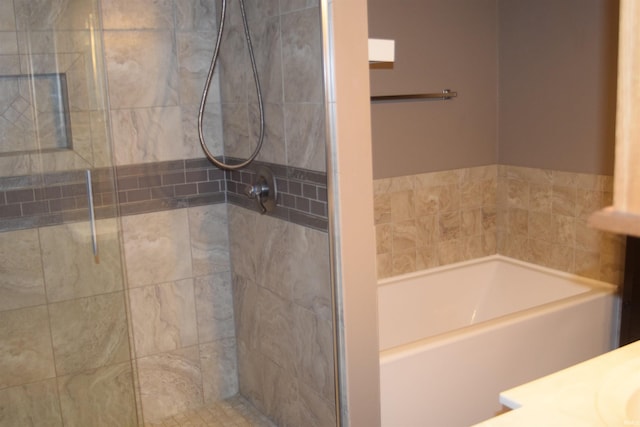 bathroom featuring shower with separate bathtub