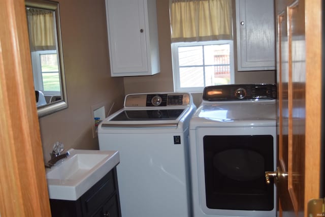 washroom with washing machine and dryer, a wealth of natural light, and sink