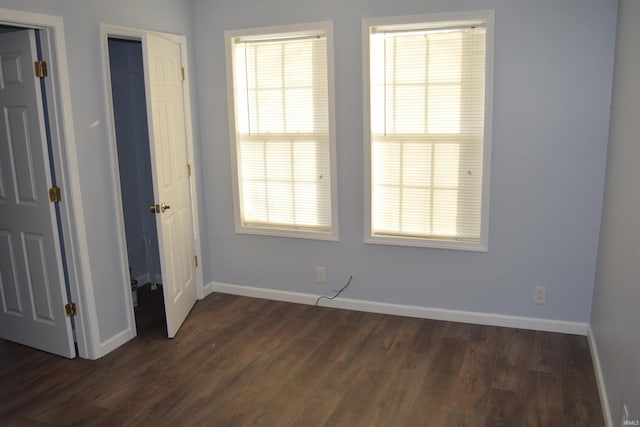 empty room with dark hardwood / wood-style flooring