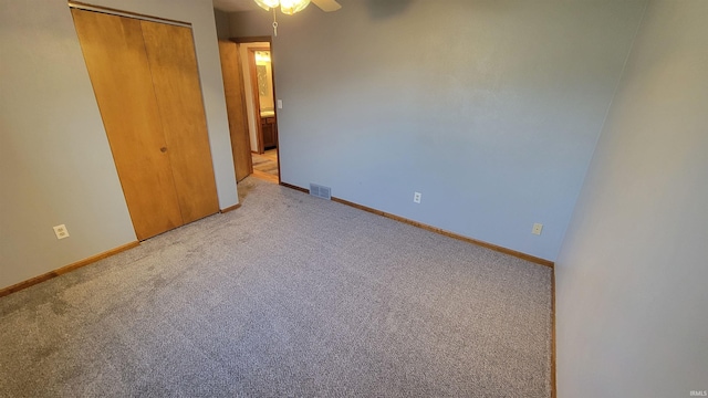 unfurnished bedroom featuring light colored carpet, a closet, and ceiling fan