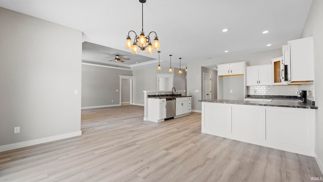 kitchen featuring white cabinets, ceiling fan with notable chandelier, decorative light fixtures, light hardwood / wood-style floors, and stainless steel appliances