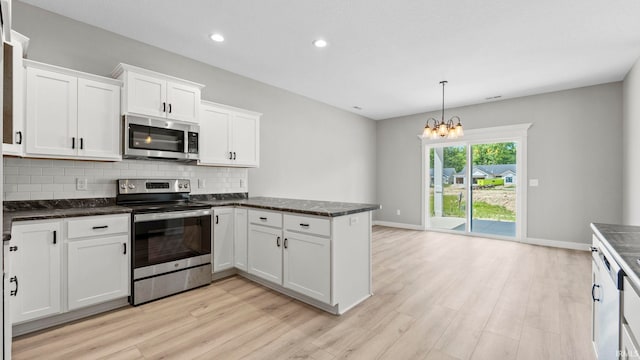 kitchen with pendant lighting, an inviting chandelier, light wood-type flooring, white cabinetry, and stainless steel appliances