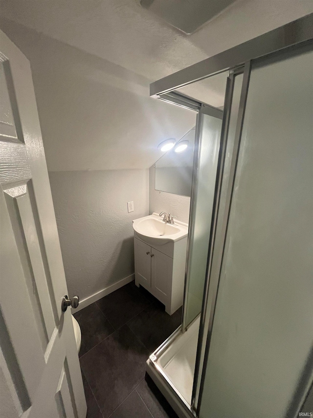 bathroom featuring tile patterned flooring, vanity, a shower with shower door, and lofted ceiling