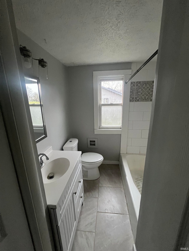 bathroom featuring tile patterned floors, vanity, a textured ceiling, and toilet