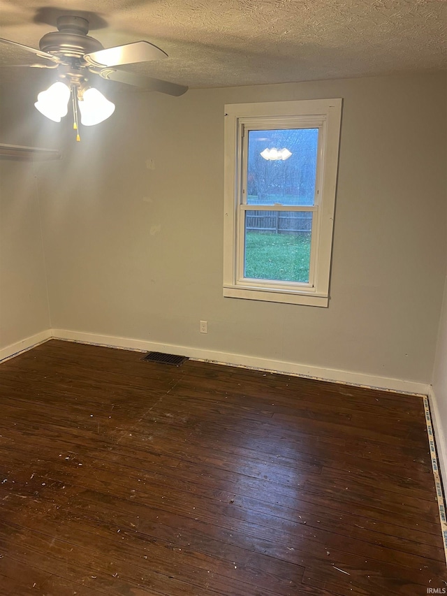 empty room featuring ceiling fan, dark hardwood / wood-style flooring, and a textured ceiling