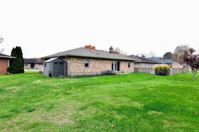 back of house featuring a storage unit and a lawn