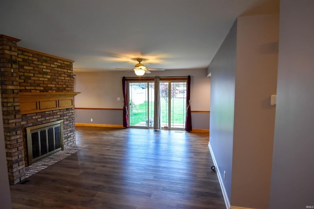 unfurnished living room featuring dark hardwood / wood-style floors, ceiling fan, and a brick fireplace