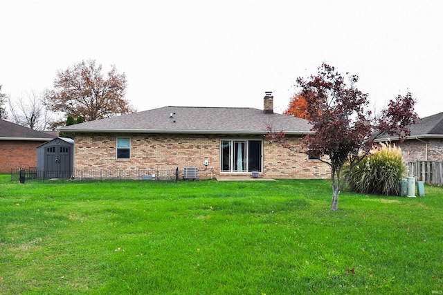 back of house with a lawn, cooling unit, and a storage shed