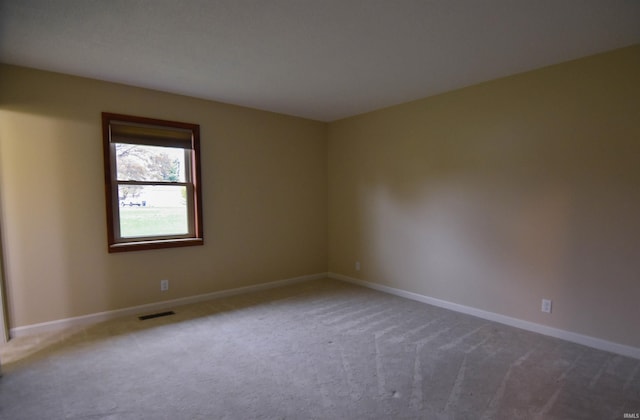 spare room featuring light carpet