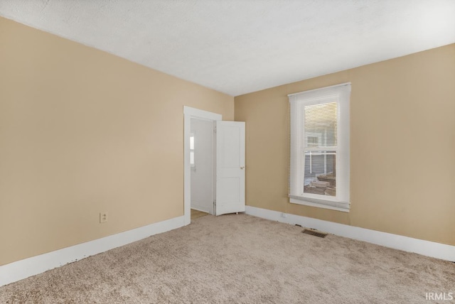 unfurnished room featuring light colored carpet