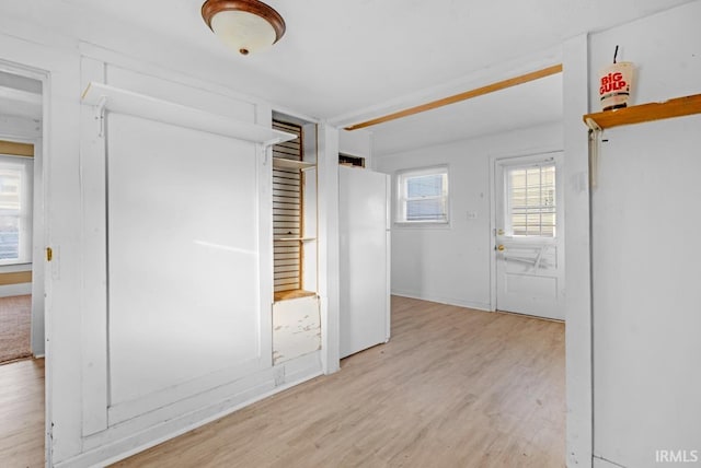 unfurnished bedroom with white refrigerator and light hardwood / wood-style flooring