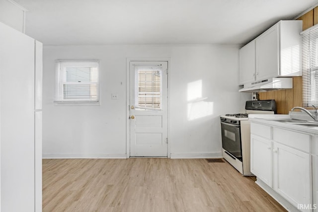 kitchen featuring white cabinetry, sink, light hardwood / wood-style flooring, and white gas range oven