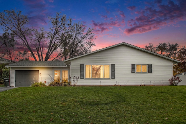 single story home with a garage and a lawn