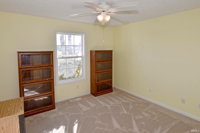 unfurnished room featuring light colored carpet and ceiling fan