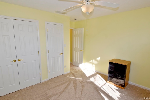 unfurnished bedroom with ceiling fan and light carpet