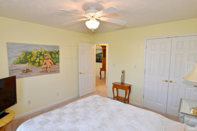 bedroom with a closet, ceiling fan, and light colored carpet