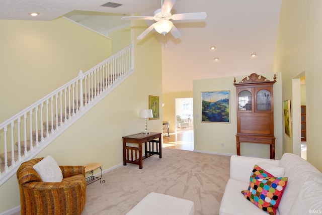 carpeted living room with ceiling fan and high vaulted ceiling