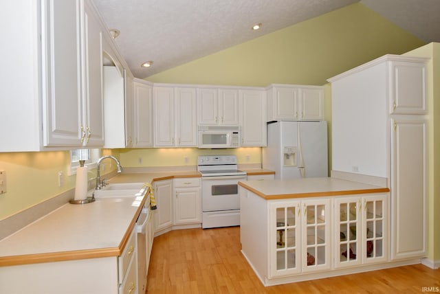 kitchen with light wood-type flooring, a textured ceiling, white appliances, sink, and white cabinetry