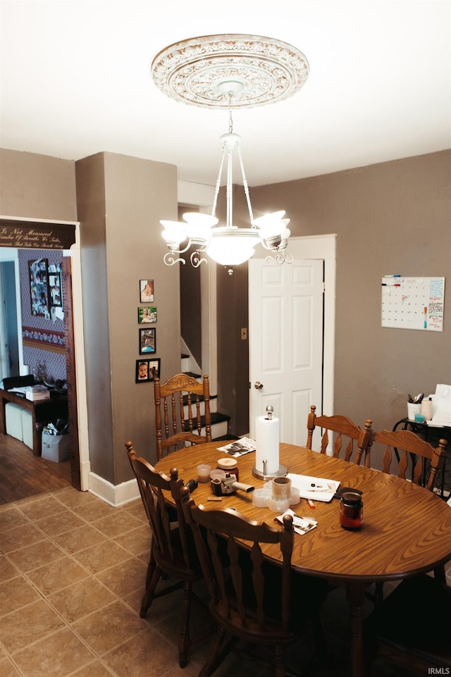 dining space with tile patterned flooring and a notable chandelier