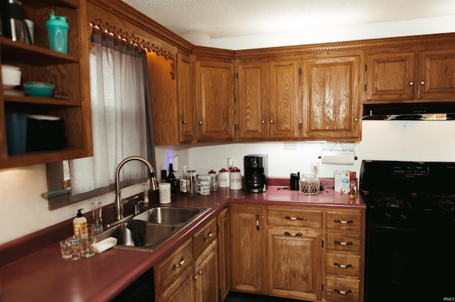 kitchen featuring a textured ceiling, black gas range, and sink