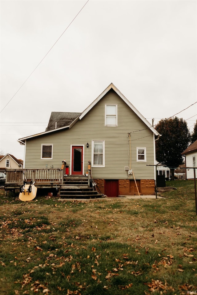 back of property with a wooden deck and a lawn