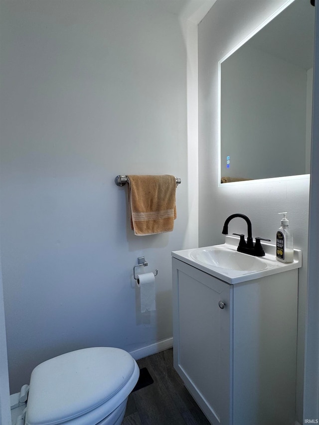 bathroom featuring hardwood / wood-style floors, vanity, and toilet