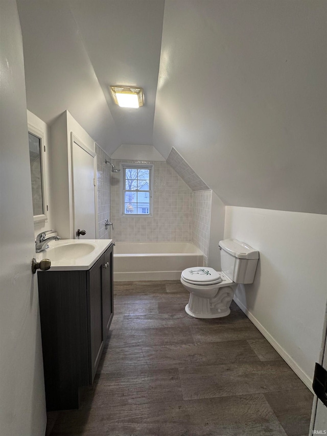 full bathroom with vanity, tiled shower / bath combo, vaulted ceiling, wood-type flooring, and toilet