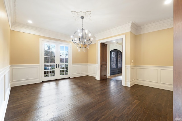 unfurnished dining area with dark hardwood / wood-style flooring, french doors, a chandelier, and ornamental molding