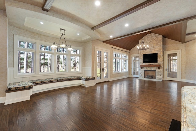 unfurnished living room featuring a fireplace, lofted ceiling with beams, dark hardwood / wood-style floors, and plenty of natural light