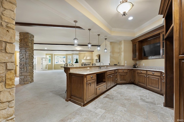 kitchen featuring light carpet, sink, hanging light fixtures, ornamental molding, and light stone countertops