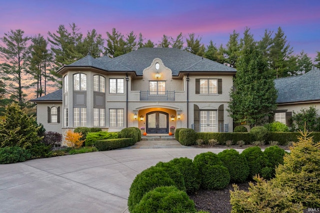 french country style house with french doors and a balcony