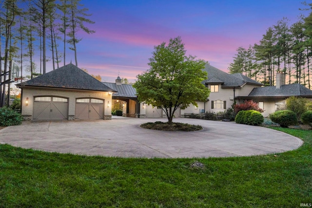 view of front of house featuring a garage and a lawn