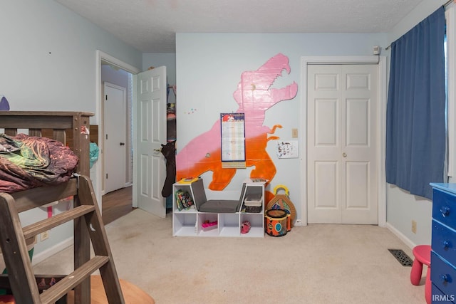 playroom featuring light colored carpet and a textured ceiling