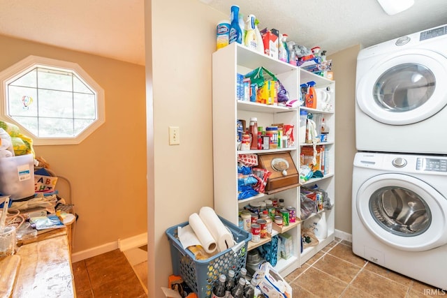 washroom with a textured ceiling, tile patterned flooring, and stacked washer and dryer