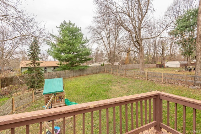 wooden terrace featuring a lawn and a playground