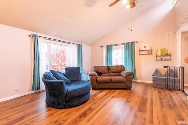 living room featuring hardwood / wood-style flooring, ceiling fan, and vaulted ceiling