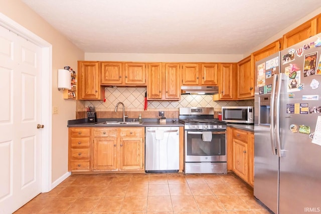 kitchen with sink, stainless steel appliances, light tile patterned floors, and decorative backsplash