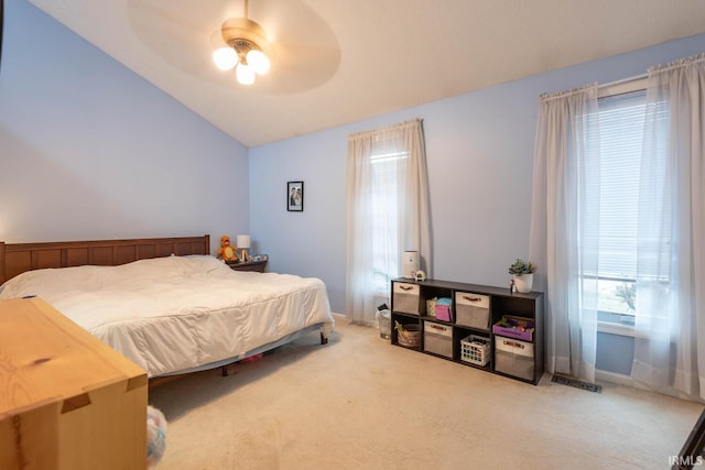 carpeted bedroom with ceiling fan and vaulted ceiling