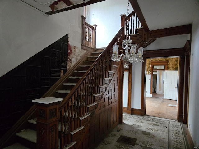 stairs featuring a chandelier and wood-type flooring