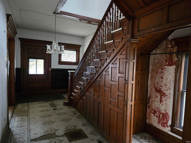 entryway featuring wooden walls and an inviting chandelier