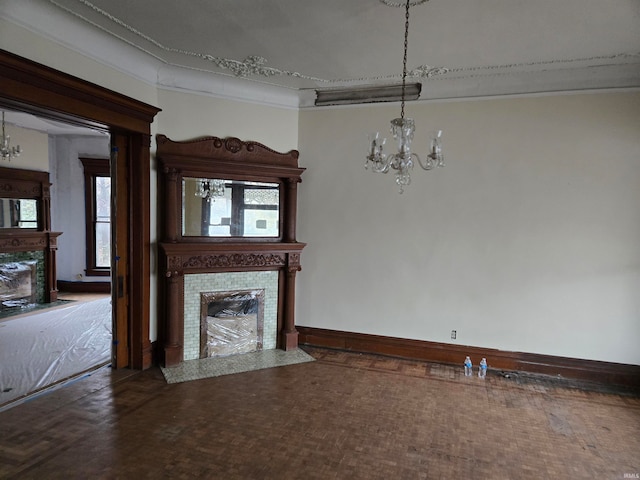 unfurnished living room featuring hardwood / wood-style flooring, an inviting chandelier, crown molding, and a tiled fireplace