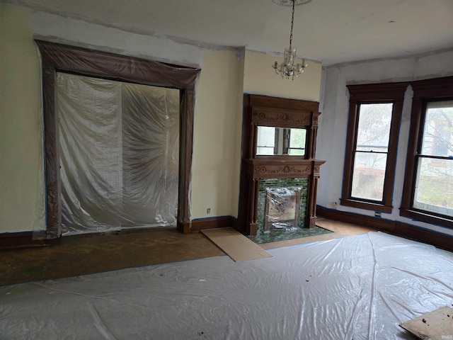 unfurnished bedroom featuring a fireplace and an inviting chandelier