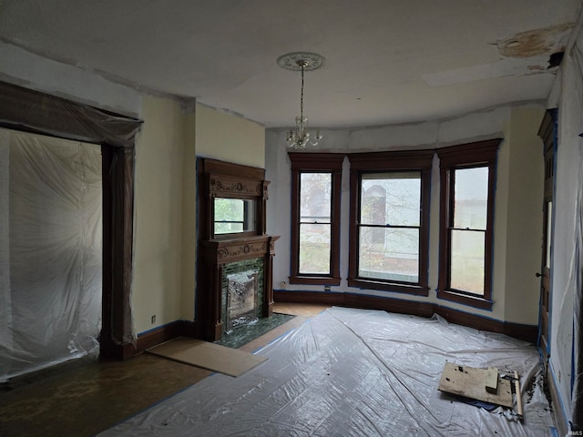 unfurnished living room featuring a chandelier and a high end fireplace