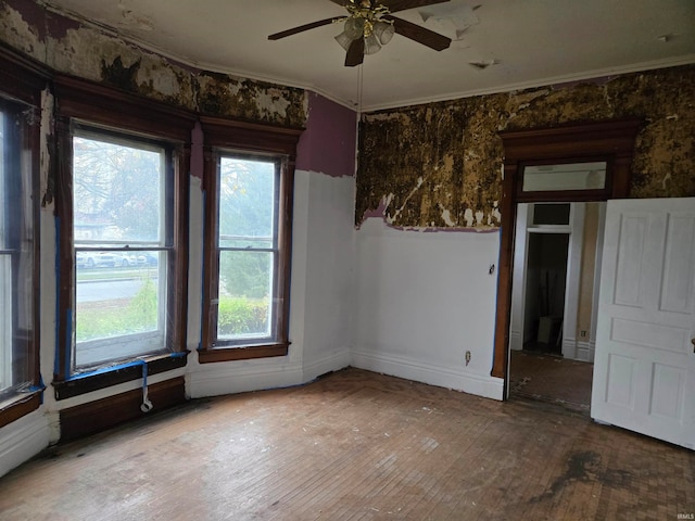 empty room featuring ceiling fan, crown molding, and hardwood / wood-style flooring