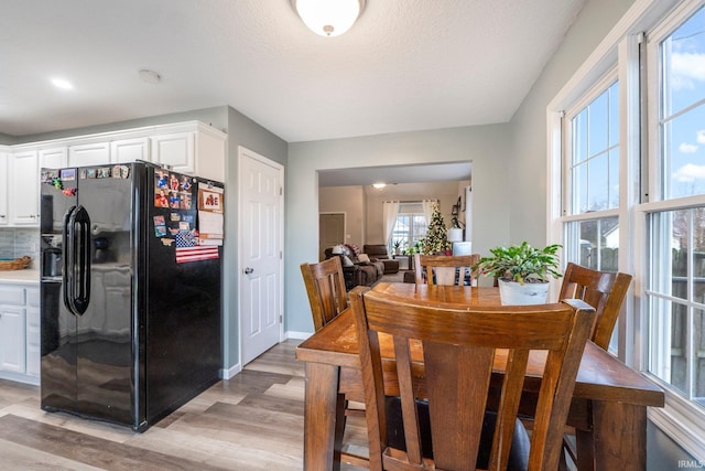 dining space featuring a textured ceiling and light hardwood / wood-style flooring